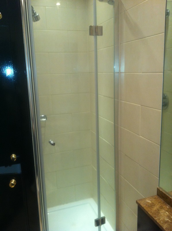 Frameless glass shower enclosure with chrome fittings in East Ham